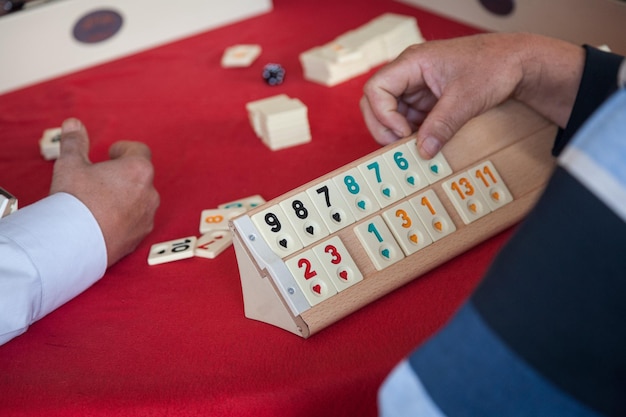 Die Leute spielen das beliebte Logik-Tischspiel Rummikub