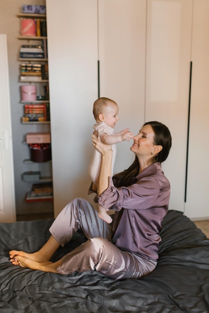 Die liebevolle Mutter spielt mit ihrem kleinen Sohn auf dem Bett