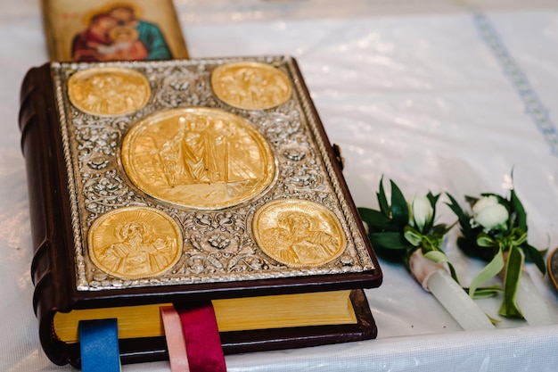 Die mit Gold und Ikonen verzierte Bibel liegt auf dem Tisch in der Kirche Nahaufnahme