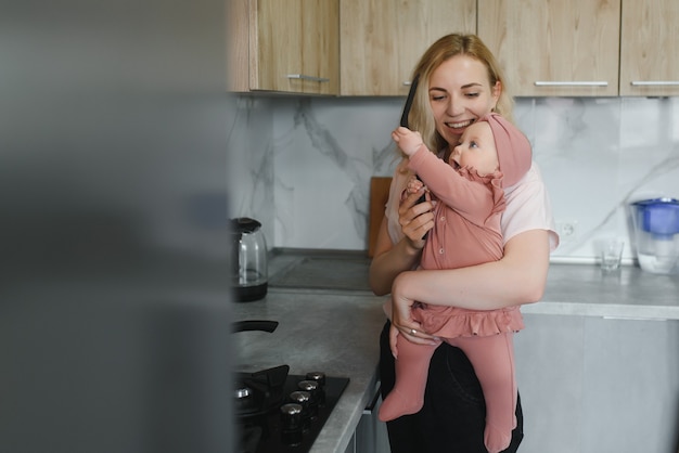 Die Mutter einer Frau mit einem Baby kocht das Essen in einem Topf auf dem Herd