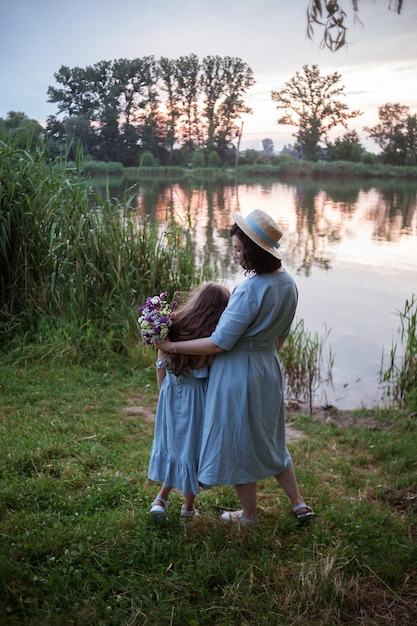 Die Mutter umarmt Tochter im Freien in der Natur