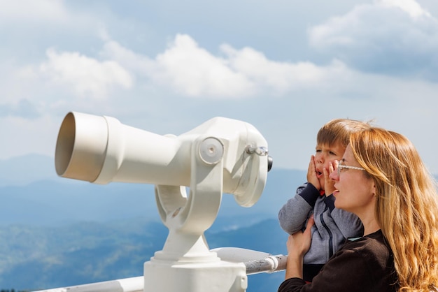 Die Mutter zeigt dem Sohn Landschaften im Tal der Rhodopen und den Himmel durch das Teleskop auf dem Aussichtsturm von Snezhan