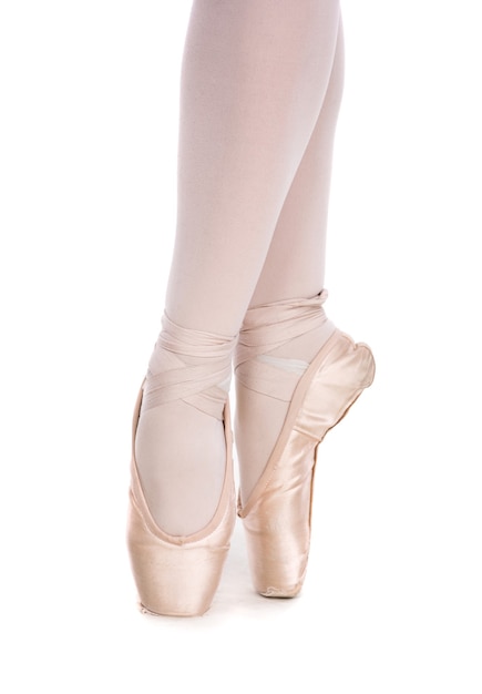 Die Nahaufnahme von Ballerina in Spitzenschuhen posiert auf weißem Hintergrund