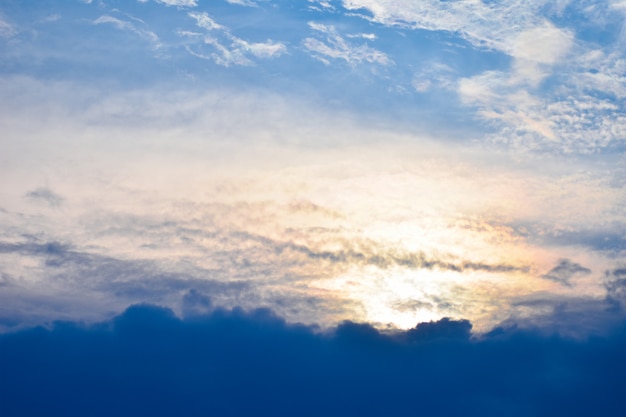 Die orangen Sonnenstrahlen bahnen sich ihren Weg durch die Abendwolken des blauen Himmels des blauen Wolkenhimmels