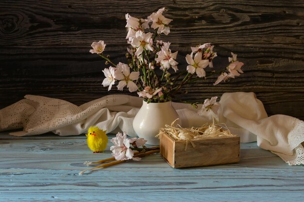 Die Osterkomposition Eier ein Bouquet von Mandelzweigen und Kirchenkerzen auf einem Holztisch in der Nähe