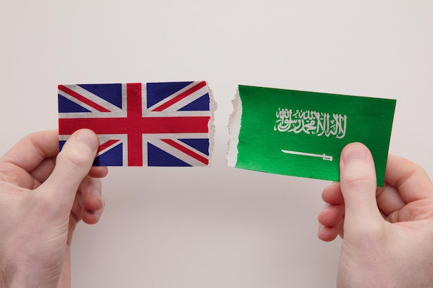 Die Papierflaggen Großbritanniens und Saudi-Arabiens zerrissen das Konzept der politischen Beziehungen