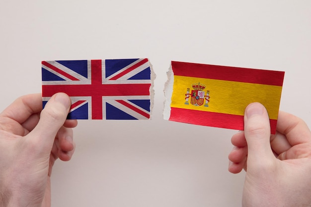 Die Papierflaggen Großbritanniens und Spaniens zerrissen das Konzept der politischen Beziehungen