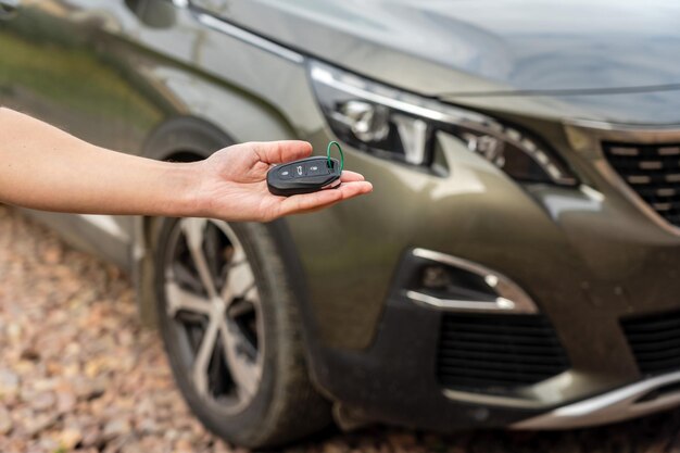 Die Person, die einen Autoschlüssel in der Hand hält, steht vor dem Autoversicherungsdarlehen und dem Kauf des Autokonzepts