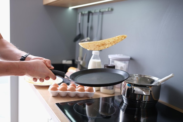 Die Person dreht die Pfannkuchen geschickt in der Pfanne um