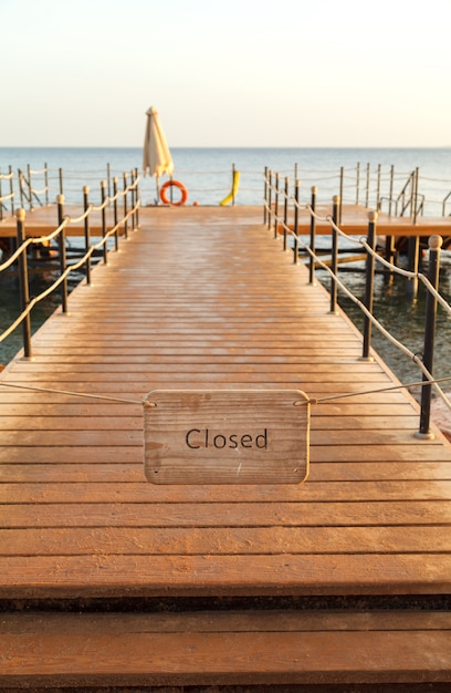 Die Platte mit der Aufschrift schloss auf einem hölzernen Pier