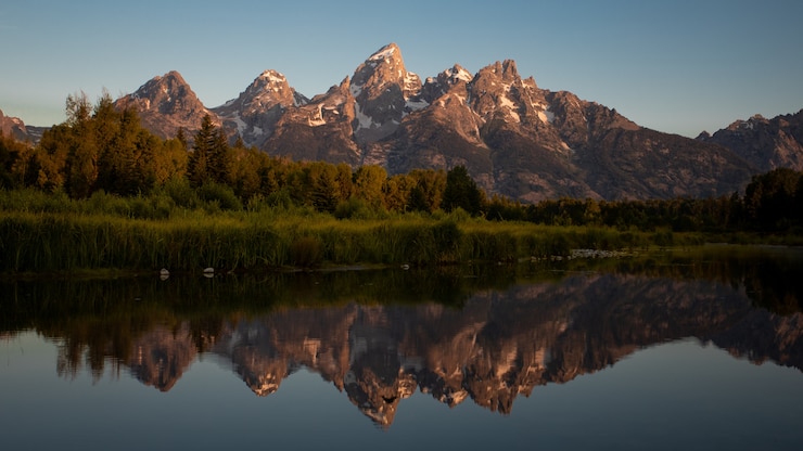 Foto die reflexion des großartigen teton nationalparks während des sonnenaufgangs