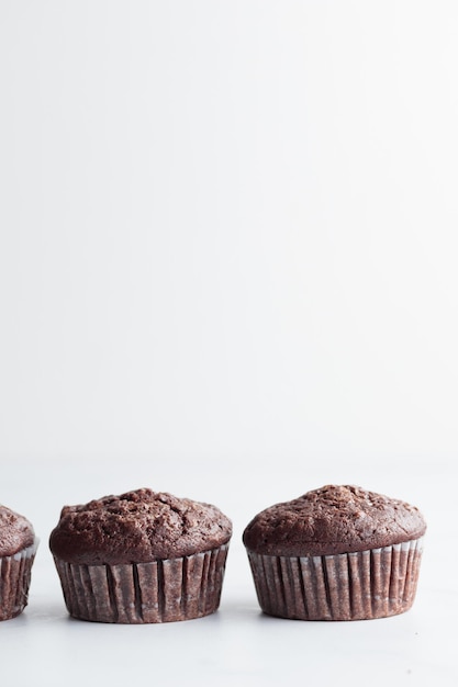 Die Reihe der Schokoladenmuffins auf einem weißen Tisch