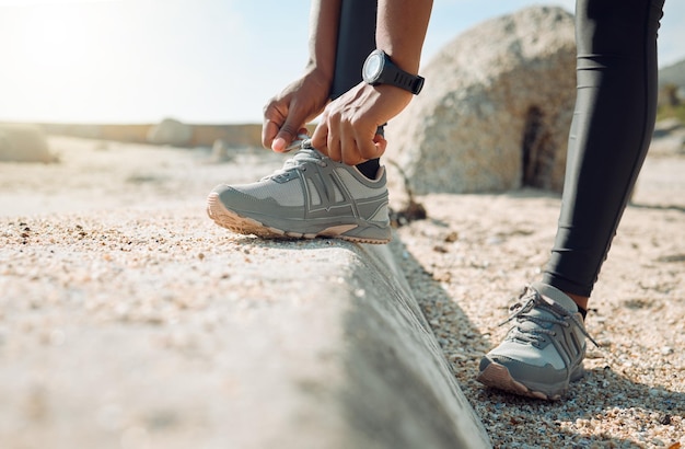 Die richtigen Schuhe bestimmen deinen Lauf. Aufnahme einer Frau, die vor dem Joggen ihre Schnürsenkel bindet.