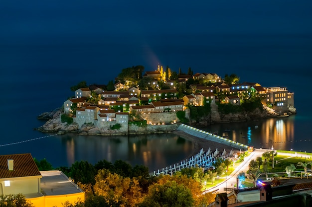 Die romantische insel sveti stefan leuchtet in der nacht im mondlicht