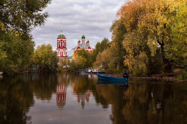 Die russische Kirche spiegelt sich im Teich wider, der von bunten Herbstbäumen umgeben ist PereslavlZalessky Russland