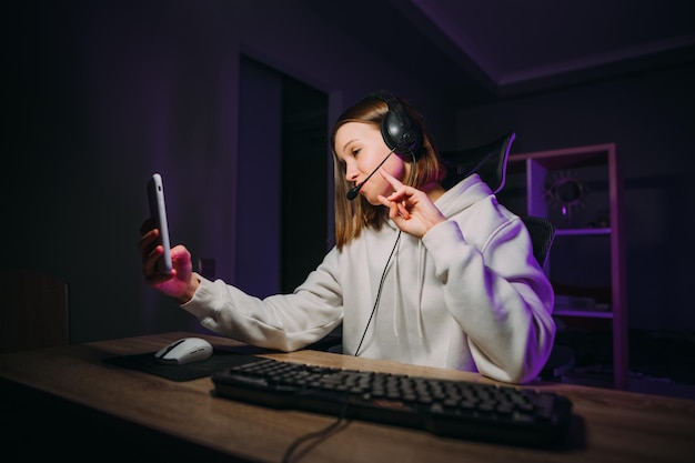 Foto die schöne dame srimer sitzt nachts mit einem headset am computer und kommuniziert