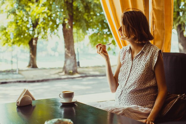 Die schwangere Frau in einem Café