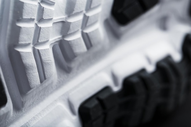Die schwarz-weiße Sohle von trendigen Sportsneakers ist eine Nahaufnahme im Vollbildmodus. Schuhdämpfungstechnologie