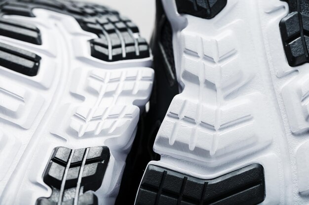 Die schwarz-weiße Sohle von trendigen Sportsneakers ist eine Nahaufnahme im Vollbildmodus.