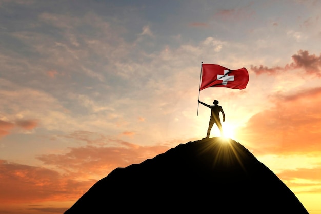 Die Schweizer Flagge wird auf der Spitze eines Berggipfels geschwenkt