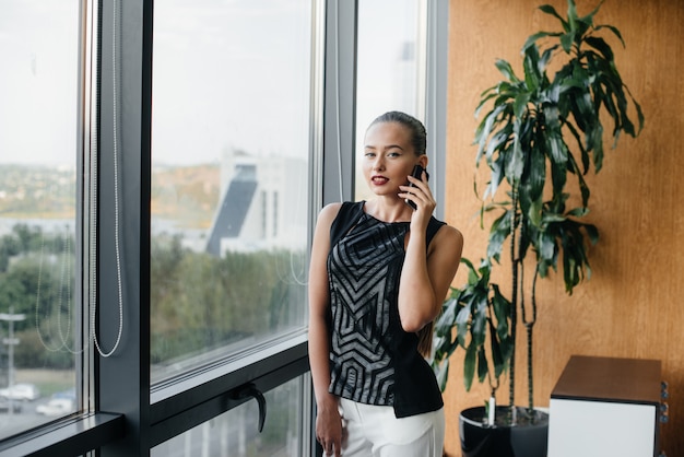 Die Sekretärin telefoniert neben dem Fenster im Büro