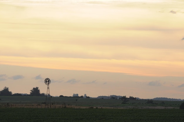 Die Silhouette einer alten Windmühle auf einem Bauernhof in einem goldenen Sonnenuntergang Barker Colonia Uruguay