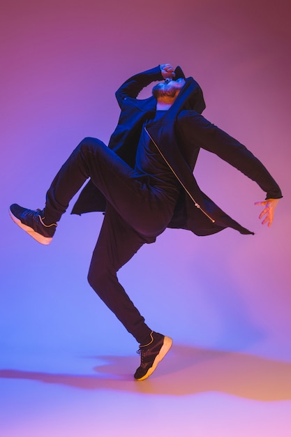 Die Silhouette eines jungen Hip-Hop-Männer Breakdancer tanzt auf buntem Hintergrund