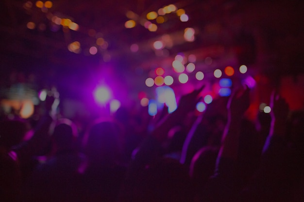 Die Silhouetten des Konzertpublikums vor hellen Bühnenlichtern. Konzert einer abstrakten Rockband