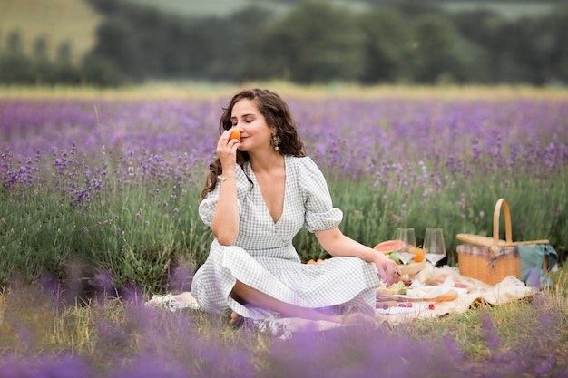 Die Sommersaison.Lavendelfelder. Ein Mädchen auf einem Picknick in den blühenden Lavendelfeldern. Urlaub auf dem Land, auf dem Land.