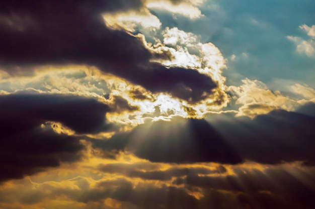 Die Sonnenstrahlen des Sonnenuntergangs am Abend durch die Gewitterwolken