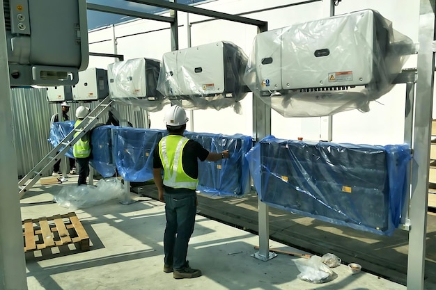 Foto die sonnenwandler werden von einem elektriker für das solardach des fabrikgebäudes installiert