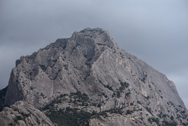 Die Spitze des Berges unter einem bewölkten natürlichen Hintergrund des stürmischen Himmels