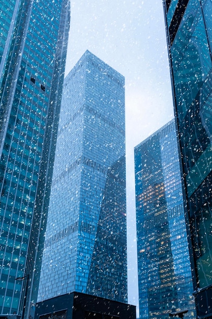 Die Spitzen der modernen Firmengebäude im Schneefall Low Angle View von Wolkenkratzern