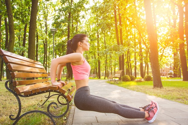 Die Sportlerin beim Sport auf der Parkbank