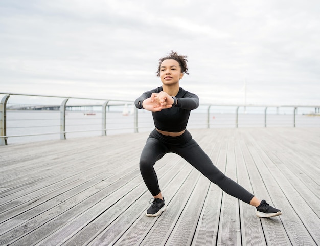 Die Sportlerin ist eine selbstbewusste Frau, die aktive Fitnessübungen mit Yoga-Elementen durchführt