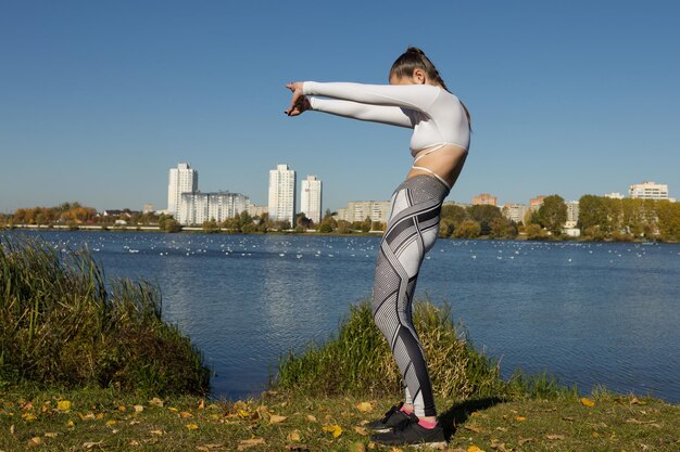 Die Sportlerin wärmt sich vor einem Lauftraining im Park auf