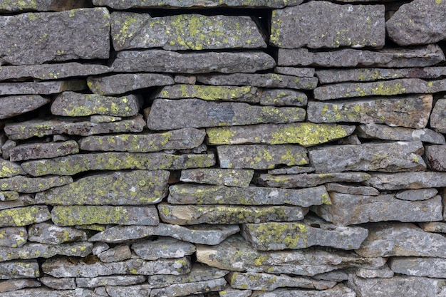 Die steinerne Festungsmauer ist mit gelbem Moos bedeckt