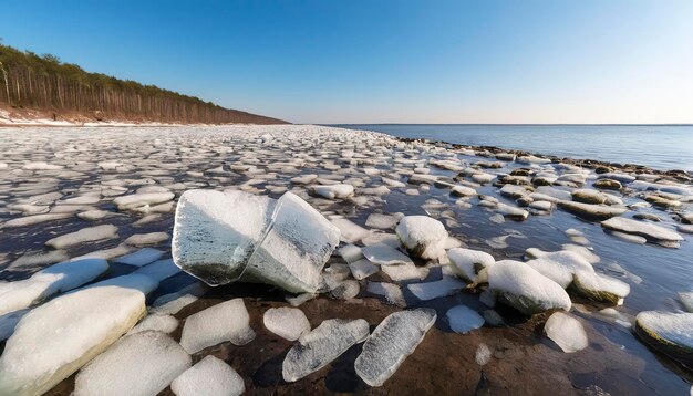 Die Steinküste der Ostsee im Frühling mit den Eisreste im Sonnenlicht