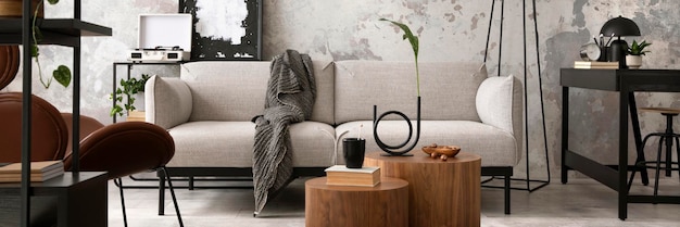 Die stilvolle Komposition im Wohnzimmerinterieur mit Design grauem Sofa Couchtisch aus Holz