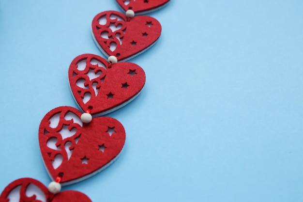 Die Stimmung von Zärtlichkeit und Liebe. Symbole des Valentinstags. Rote Herzen auf blauer Wand. Copyplace, Raum