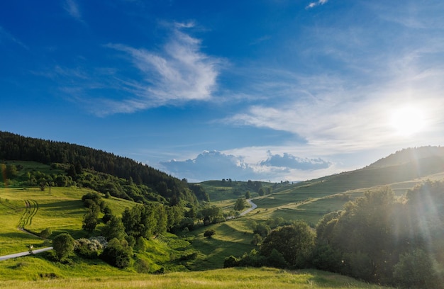 Die straße verläuft und schlängelt sich zwischen mit wäldern bedeckten hügeln vor dem hintergrund eines bewölkten himmels