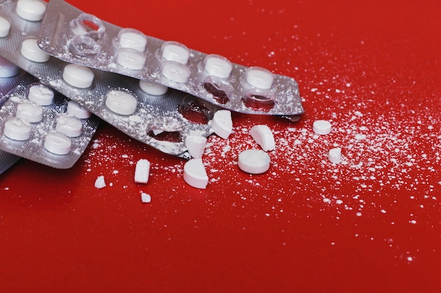 Die Tabletten sind von der Verpackung auf rot gestreut