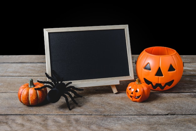 Die Tafel auf dem Stand mit Halloween Pumpkins, schwarze Spinne auf Bretterboden