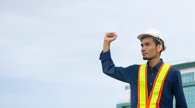 Die Technik, die Handerfolg hält und trägt einen weißen Sicherheitshut beim Arbeiten.