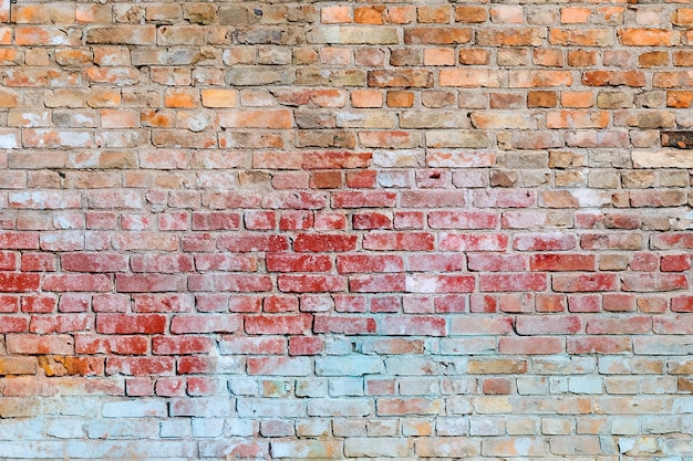 Foto die textur der alten backsteinmauer, die aus blau, rot, gelb und weiß gestrichen ist