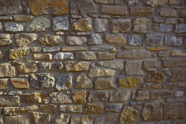 Die Textur des an der Wand ausgelegten Steins in verschiedenen Formen und Schattierungen für den gesamten Rahmen