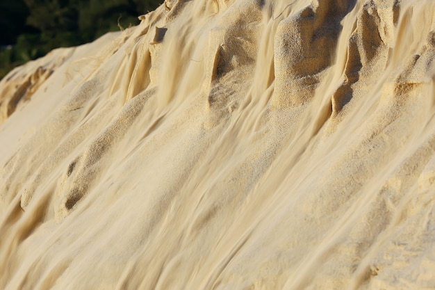 die Textur des Sandes wird von Sanddünen übertönt / Sandlawine wird von der Düne gespült, eine ungewöhnliche Sandtextur