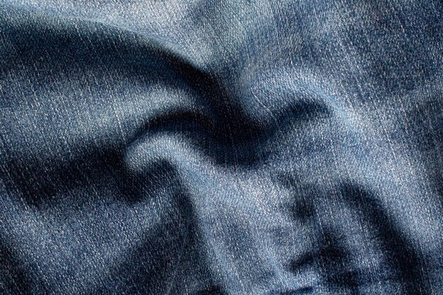 Die Textur einer Blue Jeans mit Wellen und Schattenbildung