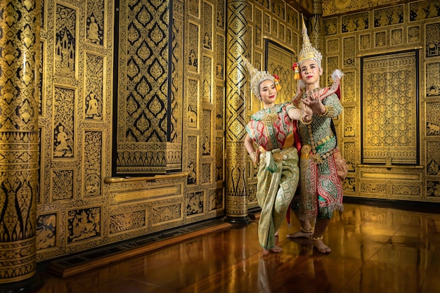 Die thailändischen Pantomimeschauspielerinnen Sita und Rama flirten miteinander. Im Bereich eines schönen goldenen Hauses im thailändischen Stil