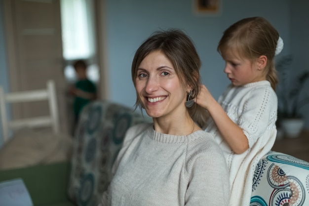 Foto die tochter flechtet die haare ihrer mutter. heimtextilien.